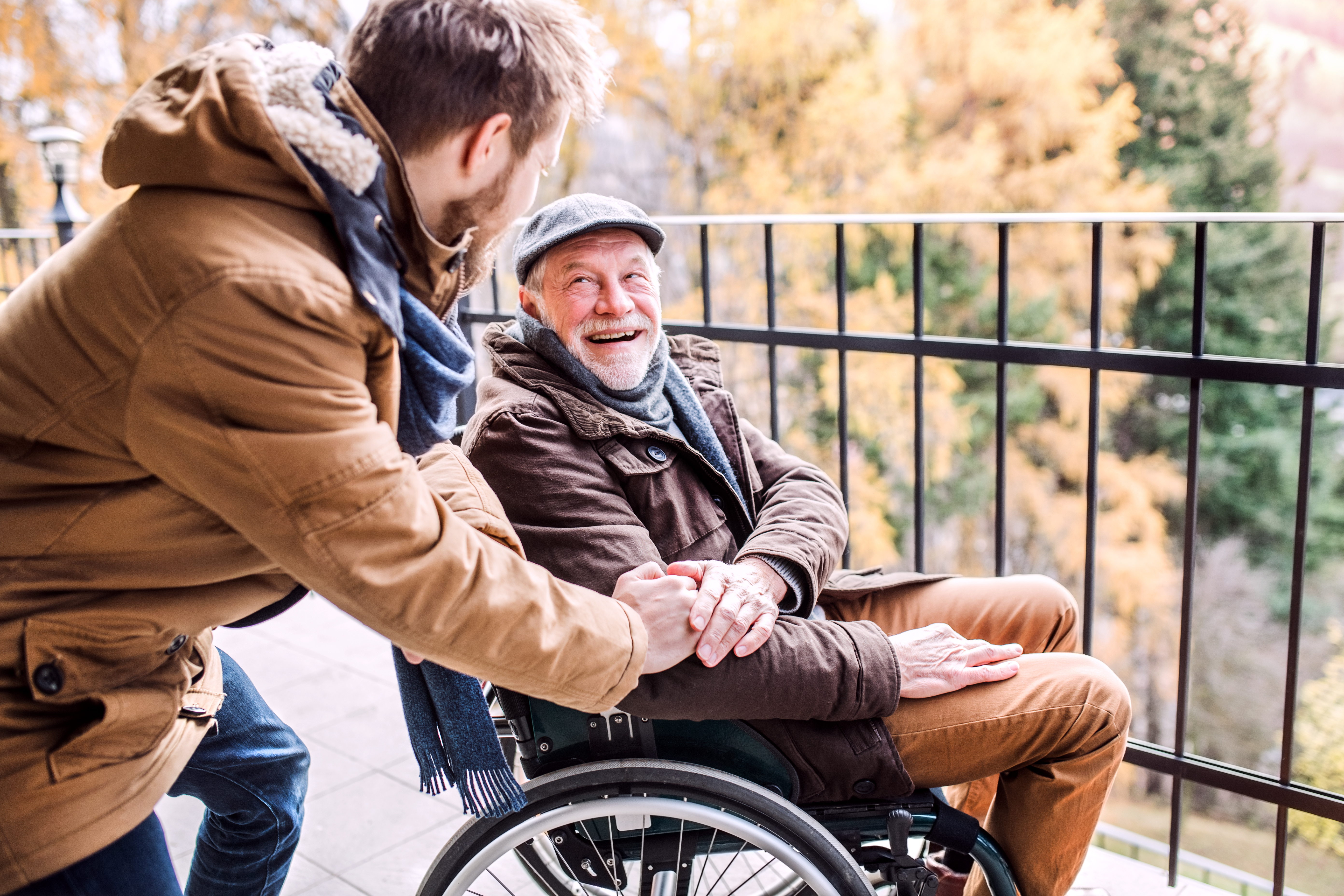 Ein Pfleger fährt mit einem glücklichem Patient, der im Rollstuhl sitzt durch Lübbenau(Spreewald)