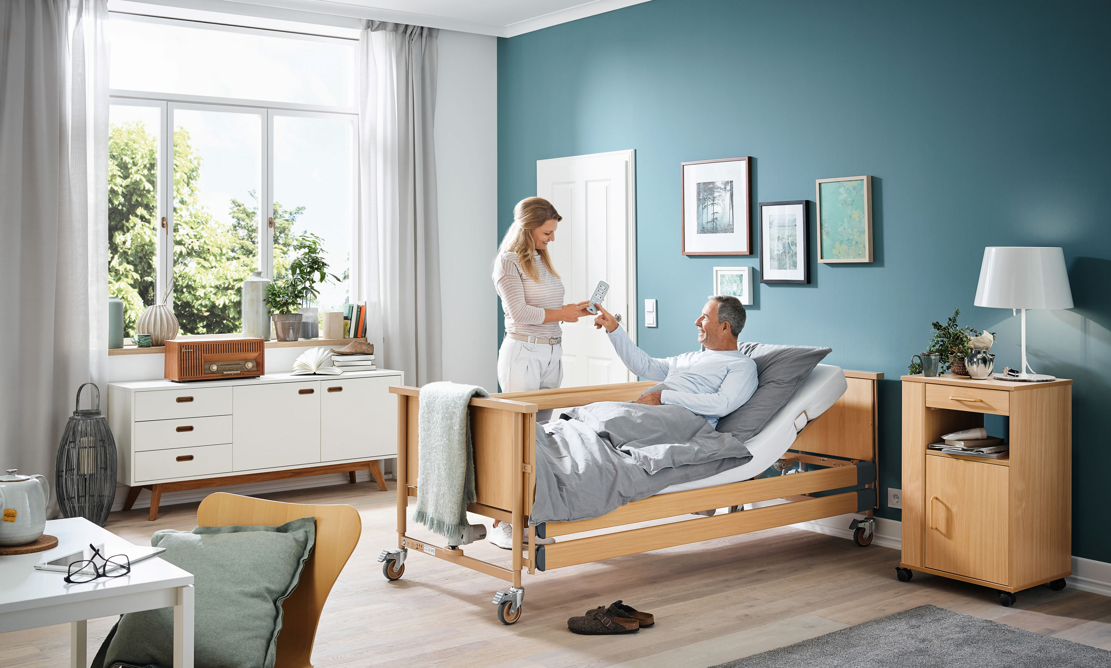 Partner für Pflegehilfsmittel vom Pflegebett bis zum Sanitärhilfsmittel - Pflegerin erklärt die Fernbedienung vom Pflegebett